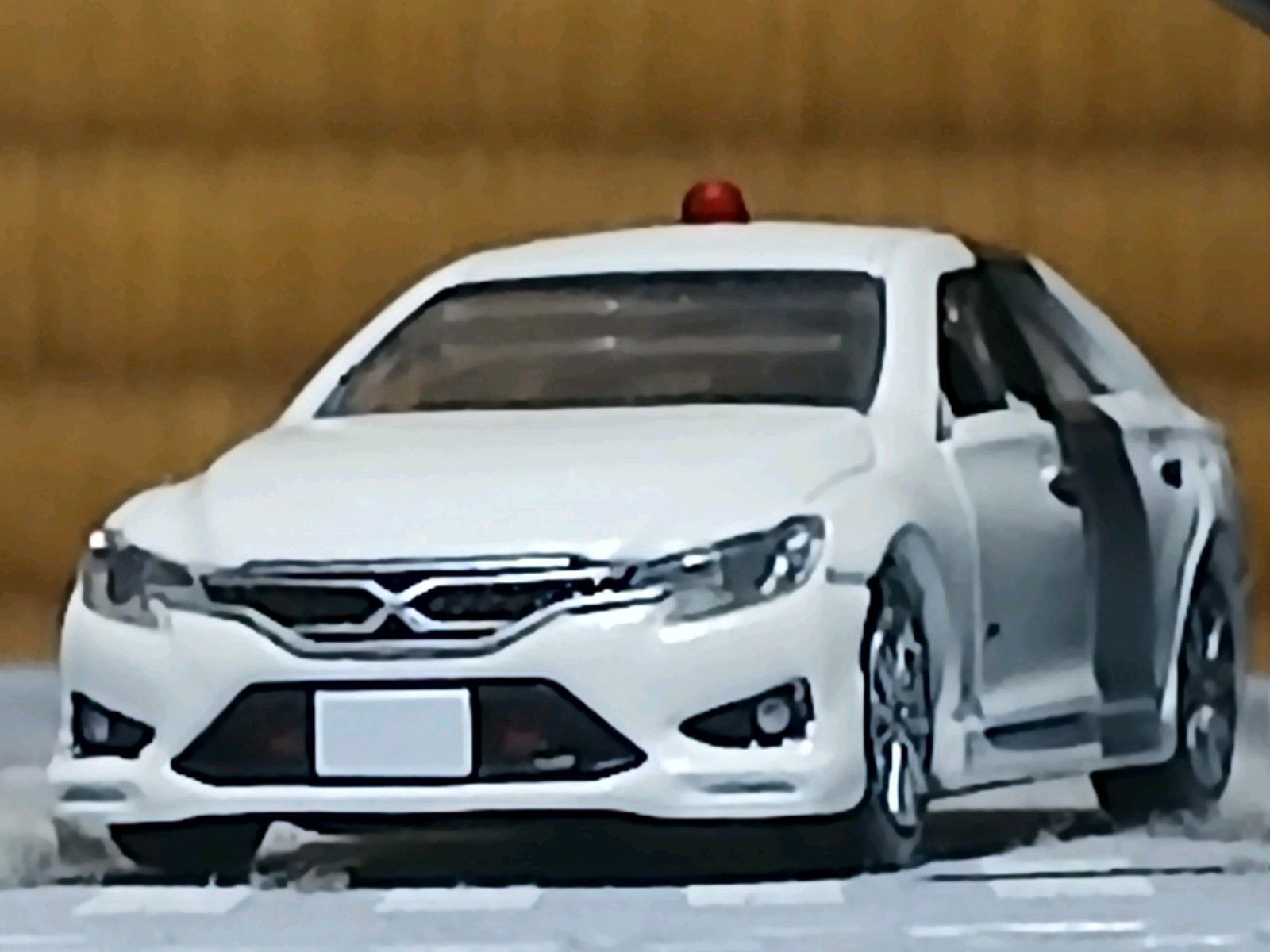 白いトヨタ・マークXの覆面パトカーが正面から写っており、屋根上の赤色灯を隠せる仕様で、警視庁が保有するTRDスーパーチャージャー搭載の高性能車という文脈が示されている。
